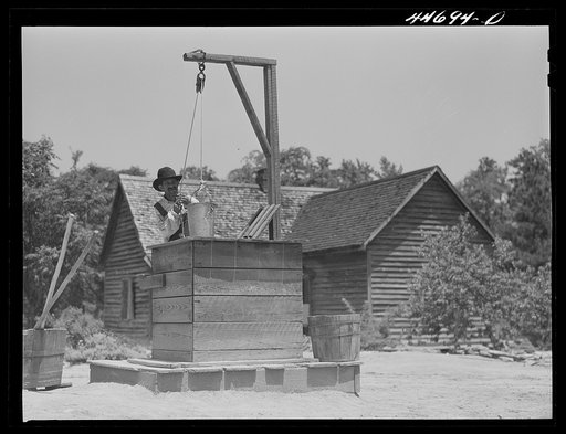 Untitled photo, possibly related to: Allen Mathews drawing water from his well. FSA (Farm Security Administration) borrower. Near Greshamville, Greene County, Georgia