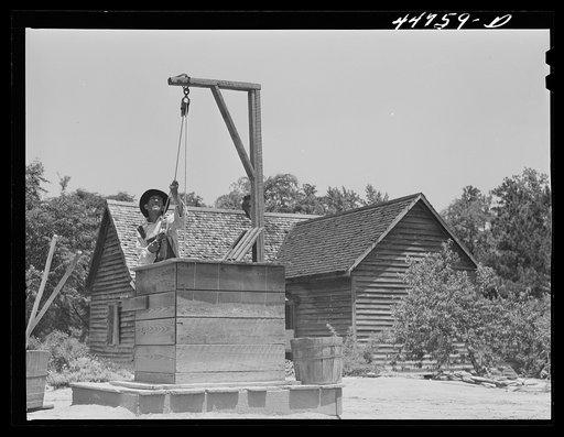 Allen Mathews drawing water from his well. FSA (Farm Security Administration) borrower. Near Greshamville, Greene County, Georgia