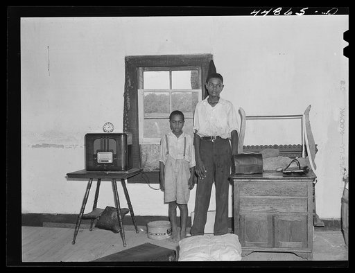 All their belongings packed, this family is waiting for the truck to move them out of the area being taken over by the Army. Caroline County, Virginia