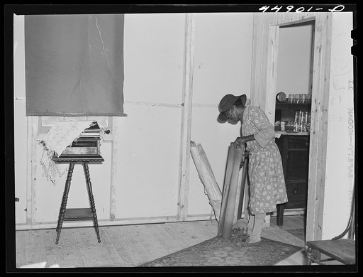 Unpacking their belongings in their new prefabricated house built by FSA (Farm Security Administration). Some farmers had to move out of the area being taken over by the Army in Caroline County, Milford, Virginia