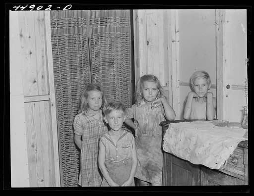 Children of a family that moved into a prefabricated house built by FSA (Farm Security Administration) to house some of the farmers who had to move out of the area being taken over by the Army in Caroline County, Virginia