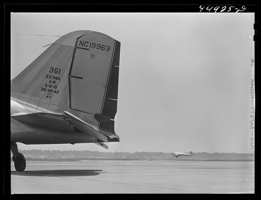 Untitled photo, possibly related to: A ground crew assistant removing the block from the rudder preparatory to the plane's taking off. Municipal airport, Washington, D.C.