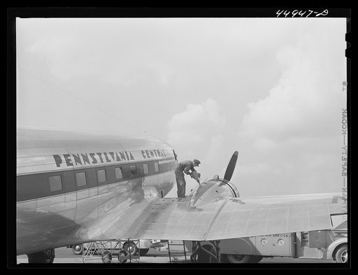 Oil for the engine of an airliner preparatory to takeoff. Municipal airport, Washington, D.C.