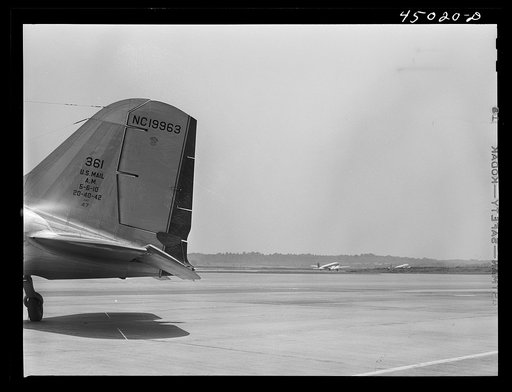 Untitled photo, possibly related to: A ground crew assistant removing the block from the rudder preparatory to the plane's taking off. Municipal airport, Washington, D.C.