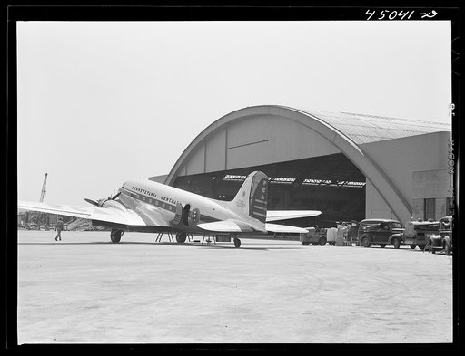 A plane in front of the huge hangar. Municipal airport, Washington, D.C.