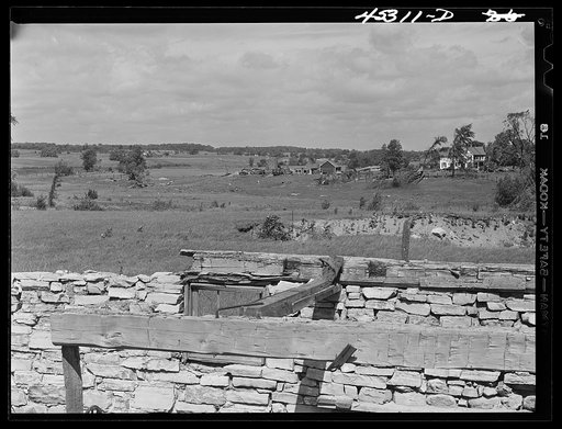 Landscape showing terrain in area being taken over by Pine Camp, New York. In foreground is a barn destroyed by hurricane. Pine Camp, New York
