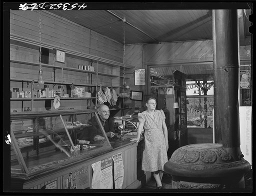 Mr. and Mrs. Merton Hoover in their store and post office in Sterlingville, New York. The Hoovers are moving out of the Pine Camp expansion area to a small house in West Carthage, New York