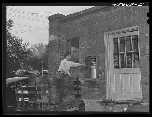 Untitled photo, possibly related to: Farmer getting his empty milk cans back at the Burlington cooperative milk bottling plant. Burlington, Vermont