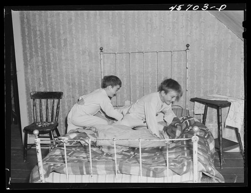 Two of the Gaynor children getting into bed on their farm near Fairfield, Vermont