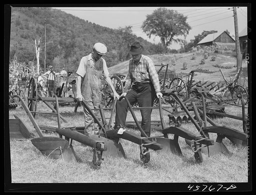 Farmers at the exhibit of old ploughs and farm implements at the World's Fair in Tunbridge, Vermont