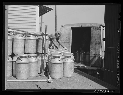 Untitled photo, possibly related to: Loading milk cans into a truck at the United Farmers' Co-op Creamery at East Berkshire, Vermont