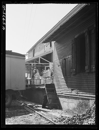 Untitled photo, possibly related to: Loading milk cans into a truck at the United Farmers' Co-op Creamery at East Berkshire, Vermont