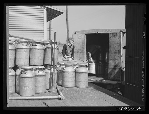 Untitled photo, possibly related to: Loading milk cans into a truck at the United Farmers' Co-op Creamery at East Berkshire, Vermont
