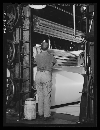 Starting a new roll of paper at the receiving end of the large rolling machine. At the Mississquoi Corporation paper mill. Sheldon Springs, Vermont