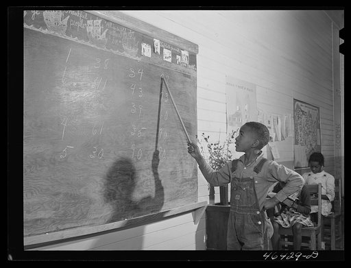 Boyd Jones doing his arithmetic lesson at the blackboard in the Alexander Community School in Greene County, Georgia