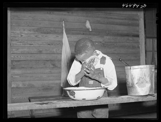Boyd Jones washing his face on the back porch of his house, Greene County, Georgia