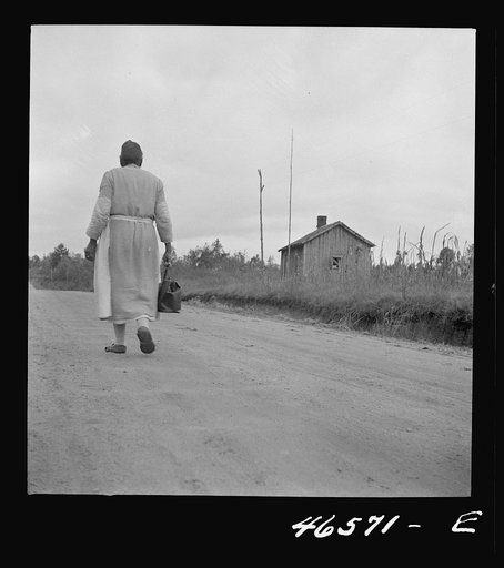 Midwife going on a call, carrying her kit, near Siloam, Greene County, Georgia