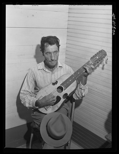 Untitled photo, possibly related to: Corozal, Puerto Rico (vicinity). Musician in the orchestra which furnished the music for dancing at the tenant purchase celebration. He is playing a "cuatro," a four-stringed guitar