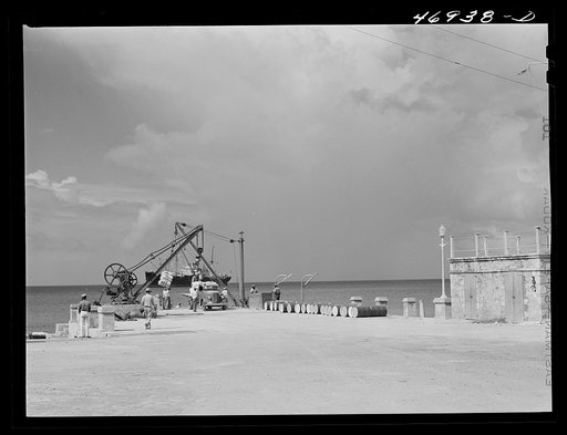 Frederiksted, Saintt Croix Island, Virgin Islands. Loading cargo on a freighter in the harbor. Because there is no pier, the ship must anchor far from shore