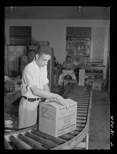 Christiansted, Saint Croix Island, Virgin Islands (vicinity). Packing bottles of rum for shipment at the Virgin Islands Company distillery