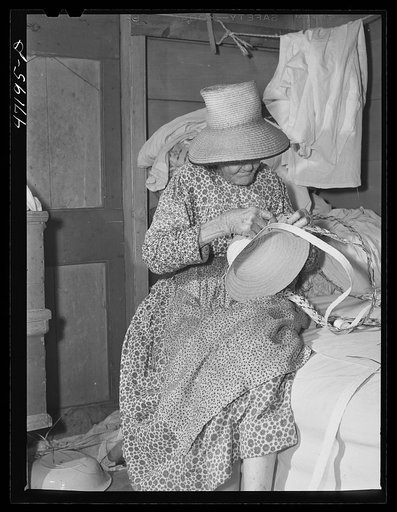 French village, a small settlement on Saint Thomas Island, Virgin Islands. Making a hat out of palm leaf to be sold at the handicrafts cooperative. Many people in the colony earn extra money this way