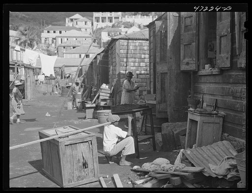 Charlotte Amalie, Saint Thomas Island, Virgin Islands. Painting furniture and cleaning house in a slum section