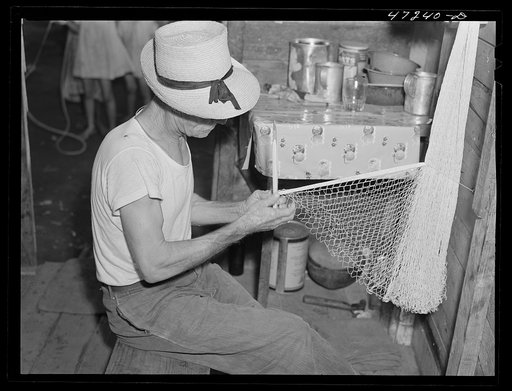 French village, a small settlement on Saint Thomas Island, Virgin Islands. French fisherman repairing his net at home in the French village, a small settlement