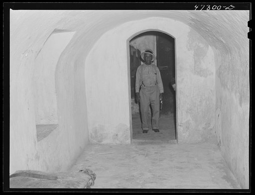 Charlotte Amalie, Saint Thomas Island, Virgin Islands. The prison warden in the doorway of the solitary dungeon at the prison in the old fort. Although the dungeon has not been in use for a long time, it is the only place in the prison for serious offenders