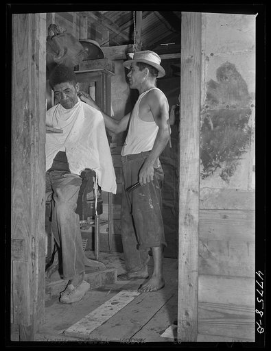 San Juan, Puerto Rico. A barber shop in the huge slum area known as "El Fangitto." The barber is a former radio mechanic and farmer