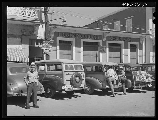 Untitled photo, possibly related to: Arecibo, Puerto Rico. A row of station wagons or "publicos" waiting for loads and passengers
