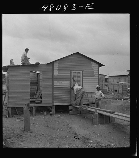 Untitled photo, possibly related to: San Juan, Puerto Rico. Painting a house just built in the huge slum area known as "El Fangitto"