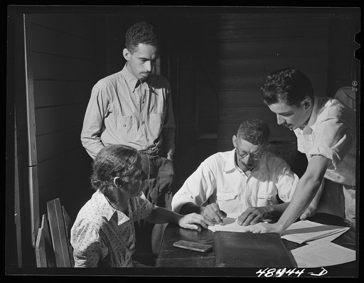 Aibonito (vicinity), Puerto Rico. FSA (Farm Security Administration) borrower and his family signing up for another loan. The county supervisor (right) is looking on