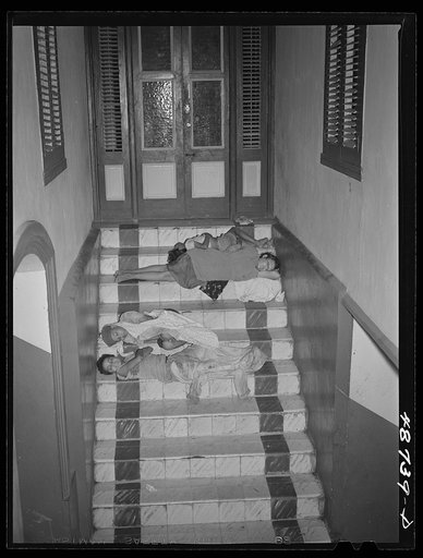 Caguas, Puerto Rico. Homeless people sleeping in the hallway of an apartment house