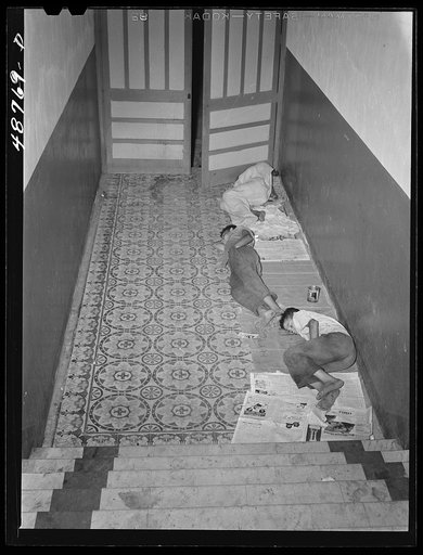Caguas, Puerto Rico. Homeless people sleeping in the hallway of an apartment house