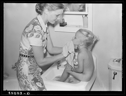 Mother and child in bathroom of new home. Greenbelt, Maryland