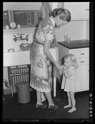 Mrs. Betty Zimmerman and child in kitchen of new home at Greenbelt, Maryland