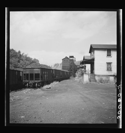 Untitled photo, possibly related to: White coal miner going to work and Negro woman taking home groceries. Company houses, coal tipple in background. Pursglove, Scotts Run, West Virginia
