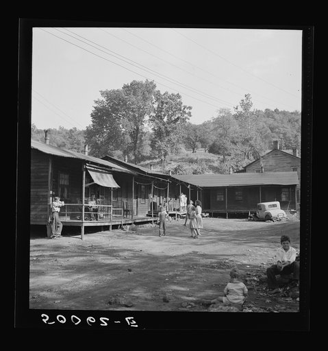 Untitled photo, possibly related to: Former coal miner sitting on his front porch. He is the town philosopher, Jere, West Virginia. Repairs his home. Note railing and potato sack awning. Experiments with an elaborate garden on a hill about two miles away. See 50081-E, 50057-E