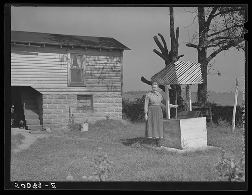 Untitled photo, possibly related to: Farm woman standing by well. West Virginia