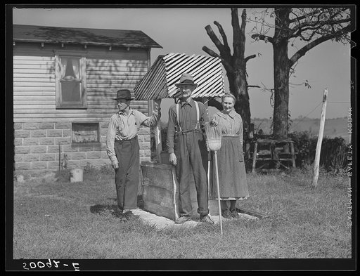Farmer, his wife and son standing by well. West Virginia