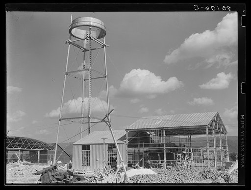 Construction, new community dimension woodworking factory for making furniture. Showing water tower. Tygart Valley, West Virginia