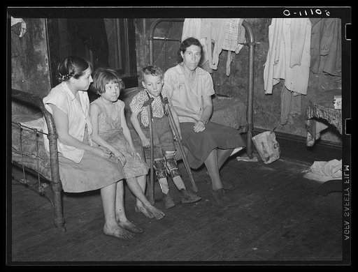 Part of one family living in miner's boarding house. One woman and six children live in one room. Two beds, no water, no heat. Mohegan, West Virginia