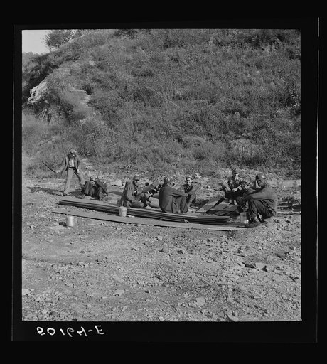 Untitled photo, possibly related to: Coal miners waiting along road for bus to take them home. In Welch, Bluefield section, West Virginia