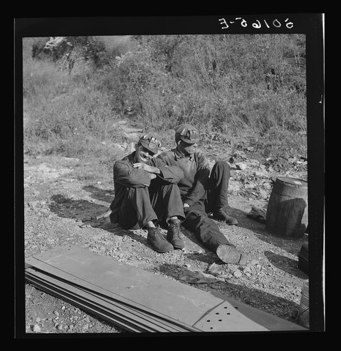 Untitled photo, possibly related to: Coal miners waiting along road for bus to take them home. In Welch, Bluefield section, West Virginia