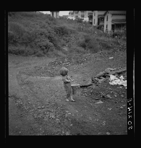Untitled photo, possibly related to: Child of miner carrying home coal she picked out of old slate pile down the hill. Pursglove, Scotts Run, West Virginia