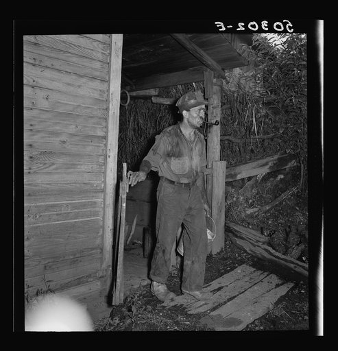 Coal miner going to get some water down the hill from his home. "The Patch," Chaplin, West Virginia