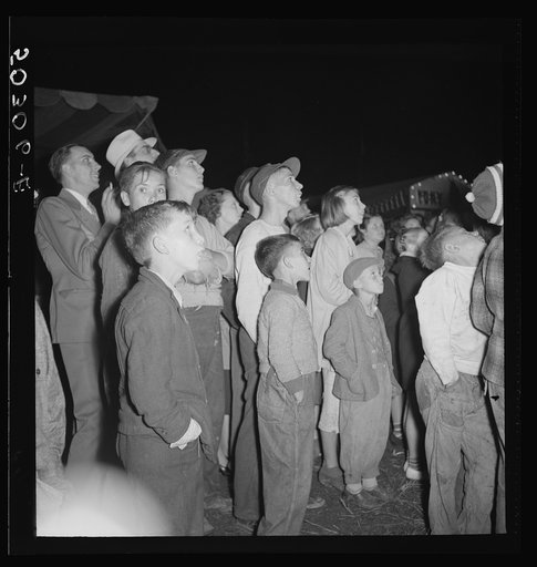 Coal miners and their families watching the girls and women's skirts blow up in the "crazy boat" at the outdoor carnival. Granville, West Virginia