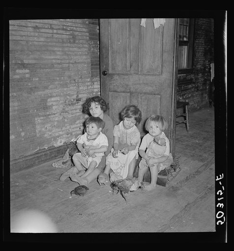 Mexican miner's children feeding chickens in the kitchen. Their mother is thirty years old and has had ten children. Scotts Run, Bertha Hill, West Virginia