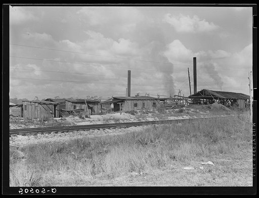 Small sawmill, Childs, Florida. Owned by "wealthy" man, Mr. Warren, in Fort Meade, Florida. Negro workers build their own shacks out of old lumber from around there, work ten hours a day for two dollars, six days a week. The children don't go to school