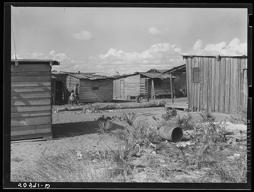 Negro sawmill workers' homes: no light, no privies, one outdoor water pump for whole camp. Childs, Florida